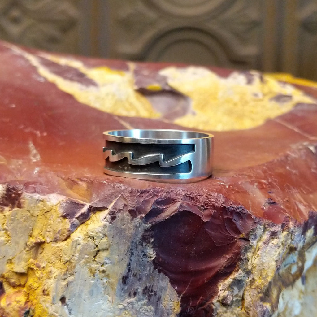 Sterling silver ring with zigzag patterns on its surface.