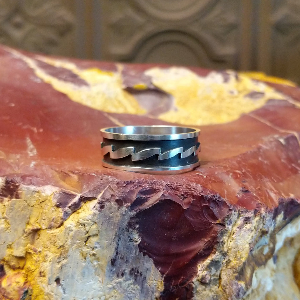 Sterling silver ring with zigzag patterns on its surface.
