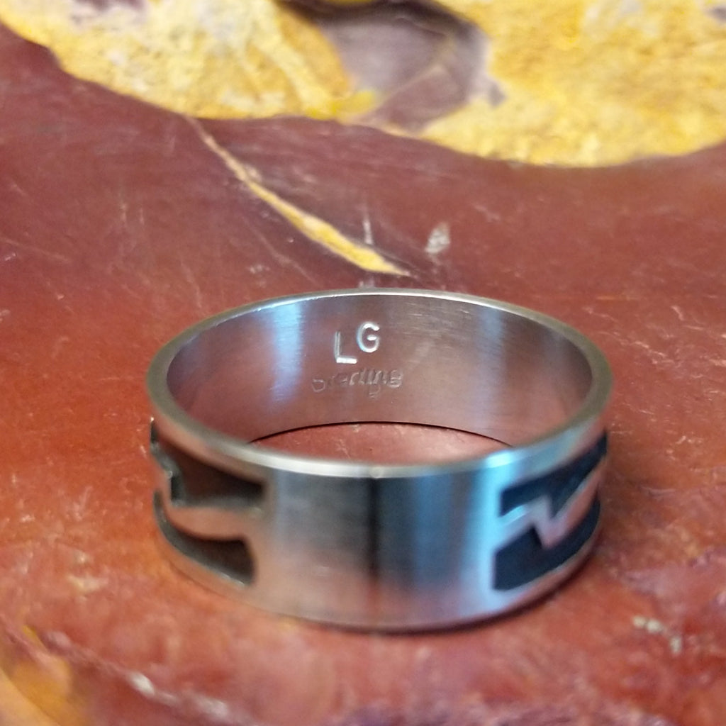 The interior of the ring features the artisan's signature.