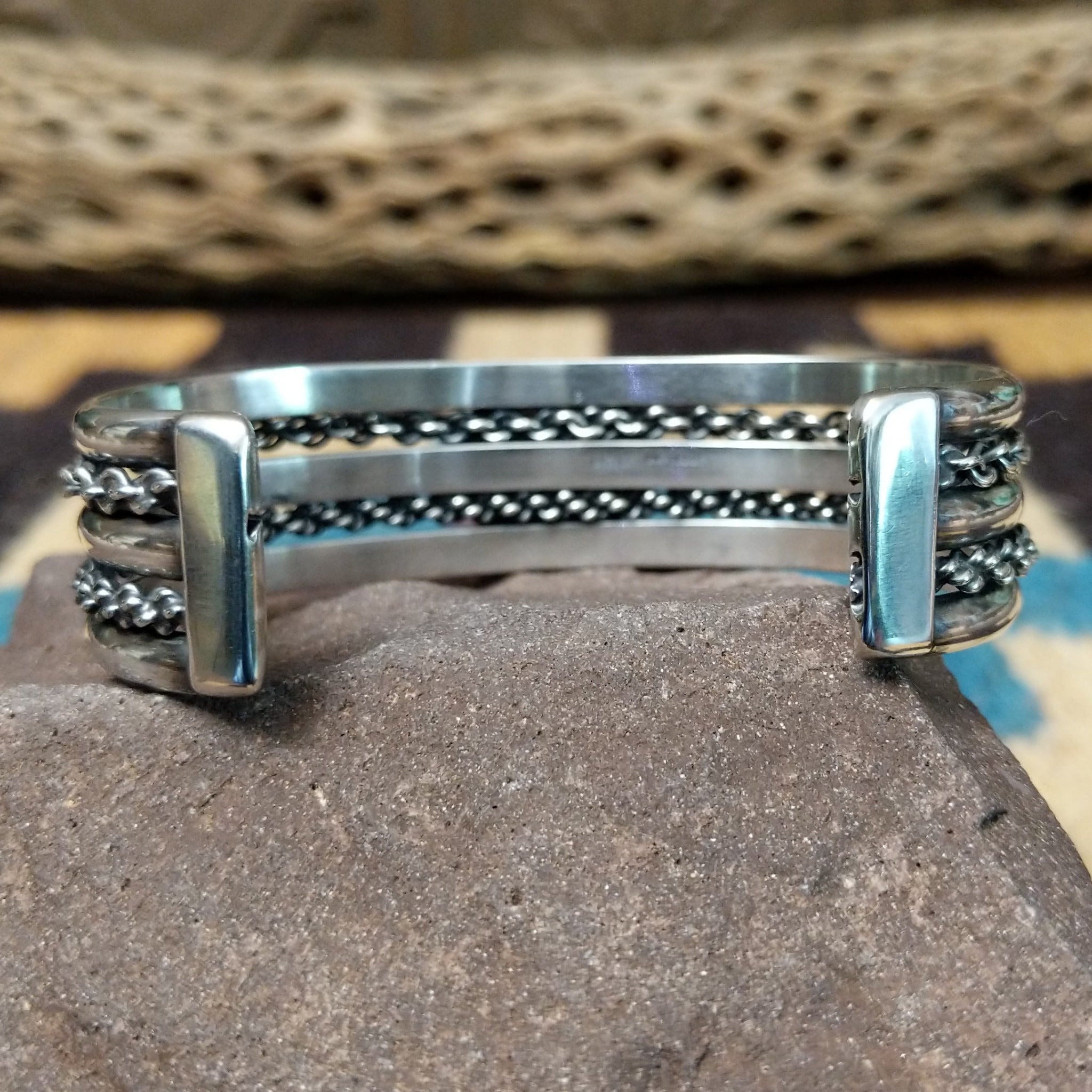 Navajo Sonoran Gold turquoise cuff by H.R.M., featuring an oval blue and green Sonoran Gold turquoise stone with natural matrix set in a handcrafted sterling silver cuff with twisted chain accents; underside view.