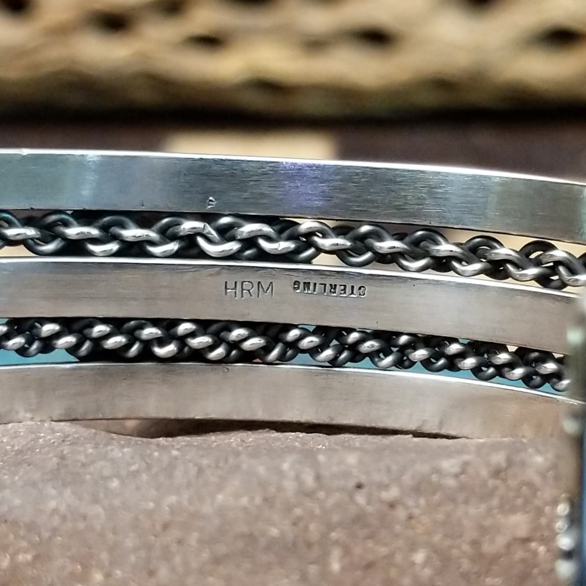 Navajo Sonoran Gold turquoise cuff by H.R.M., featuring an oval blue and green Sonoran Gold turquoise stone with natural matrix set in a handcrafted sterling silver cuff with twisted chain accents; artisan and Sterling Silver stamp.