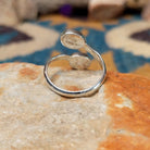 Handcrafted Navajo sterling silver bypass ring featuring two oval Sonoran Gold turquoise cabochons in smooth bezel settings, with vibrant blue and green natural turquoise on a polished open-band design; underside view.