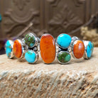 Sterling silver bracelet with turquoise and orange spiny oyster shell set in multiple bezels.