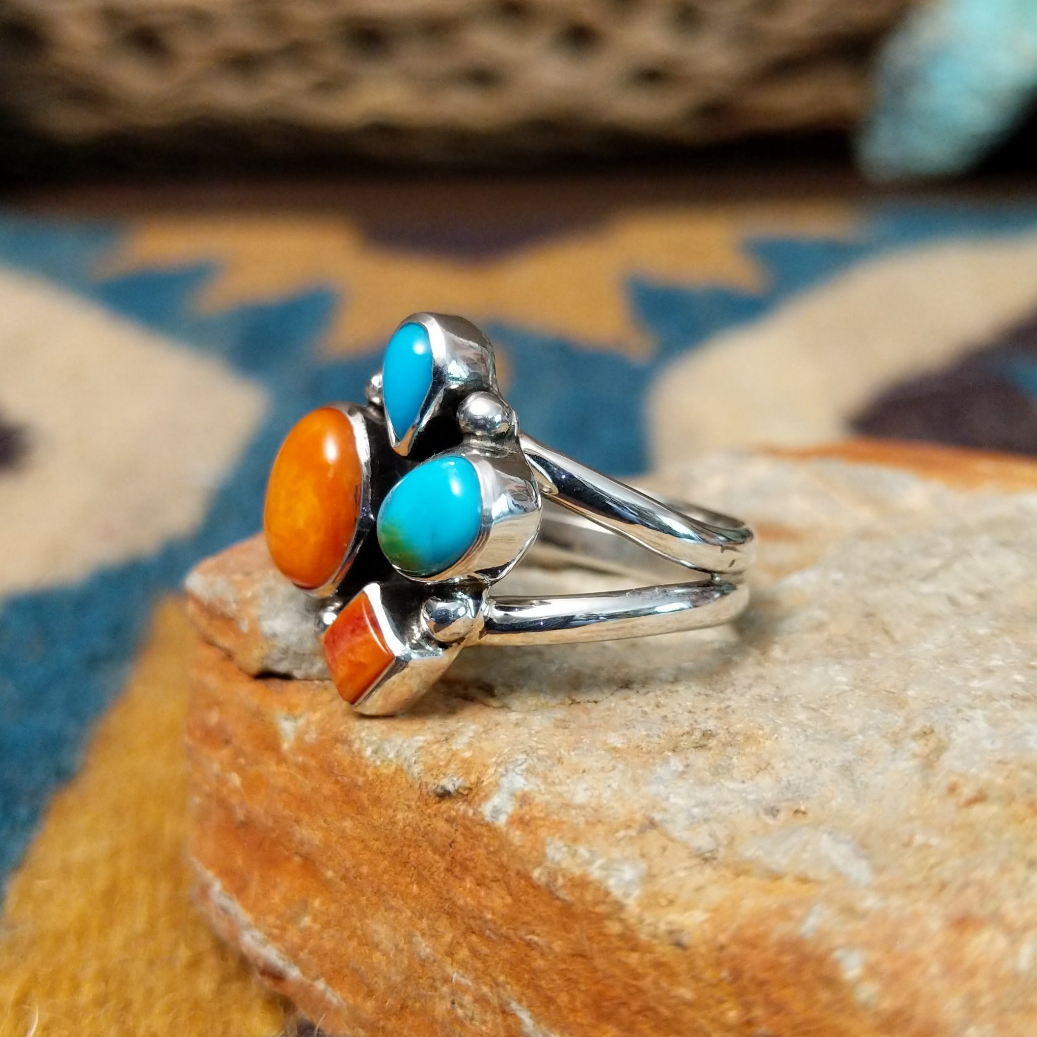 Handcrafted sterling silver Navajo Sonoran Gold turquoise and orange spiny oyster ring, featuring a colorful asymmetrical cluster design; side view.