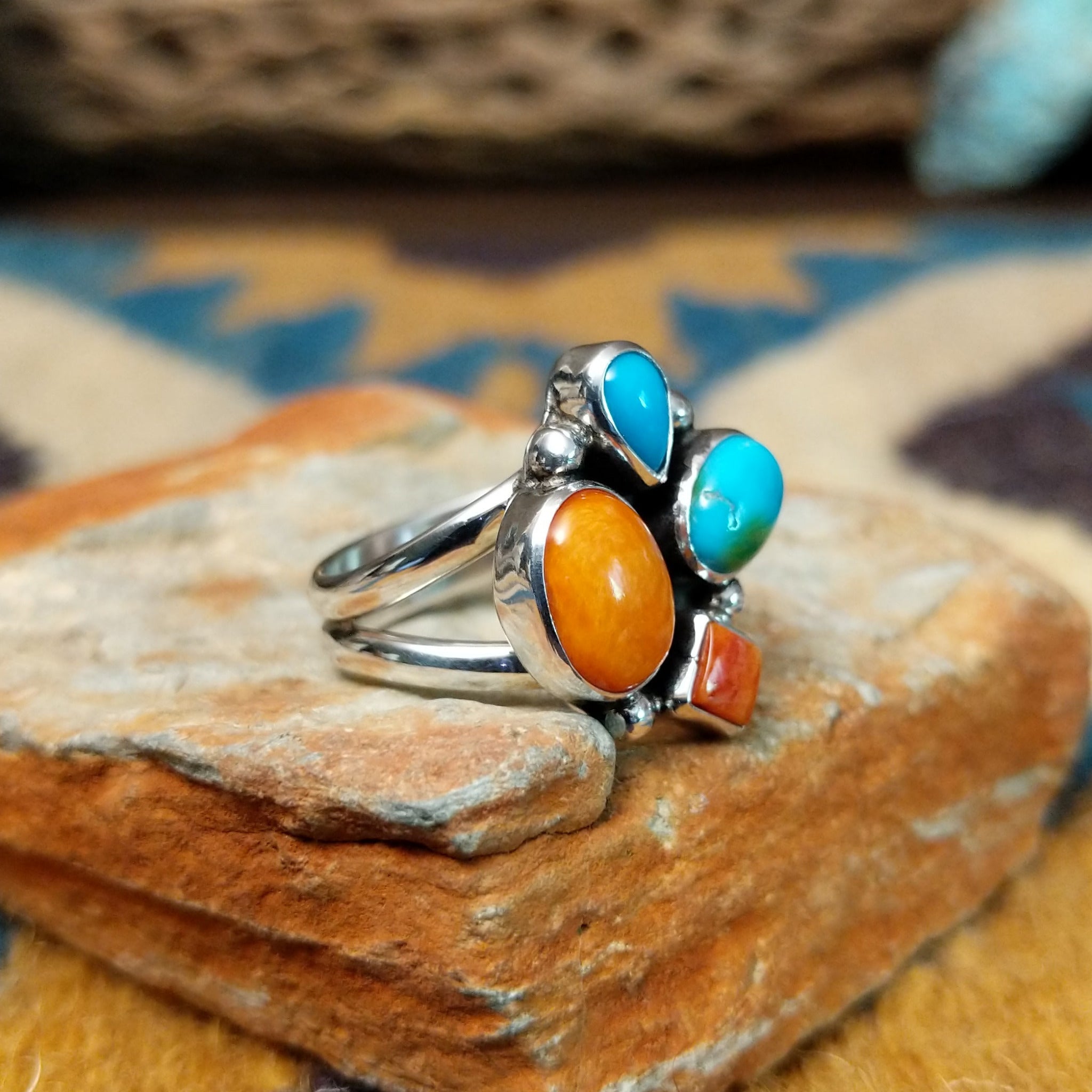 Handcrafted sterling silver Navajo Sonoran Gold turquoise and orange spiny oyster ring, featuring a colorful asymmetrical cluster design; side view.