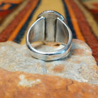 Navajo Sonoran Gold Turquoise Ring by S.N. featuring a large oval green and turquoise stone with natural matrix patterns, a twisted silver rope border, and a wide silver band with stamped sunburst detailing; underside view.
