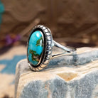Sterling silver ring with Sonoran gold turquoise set in an oval, shadowbox setting.
