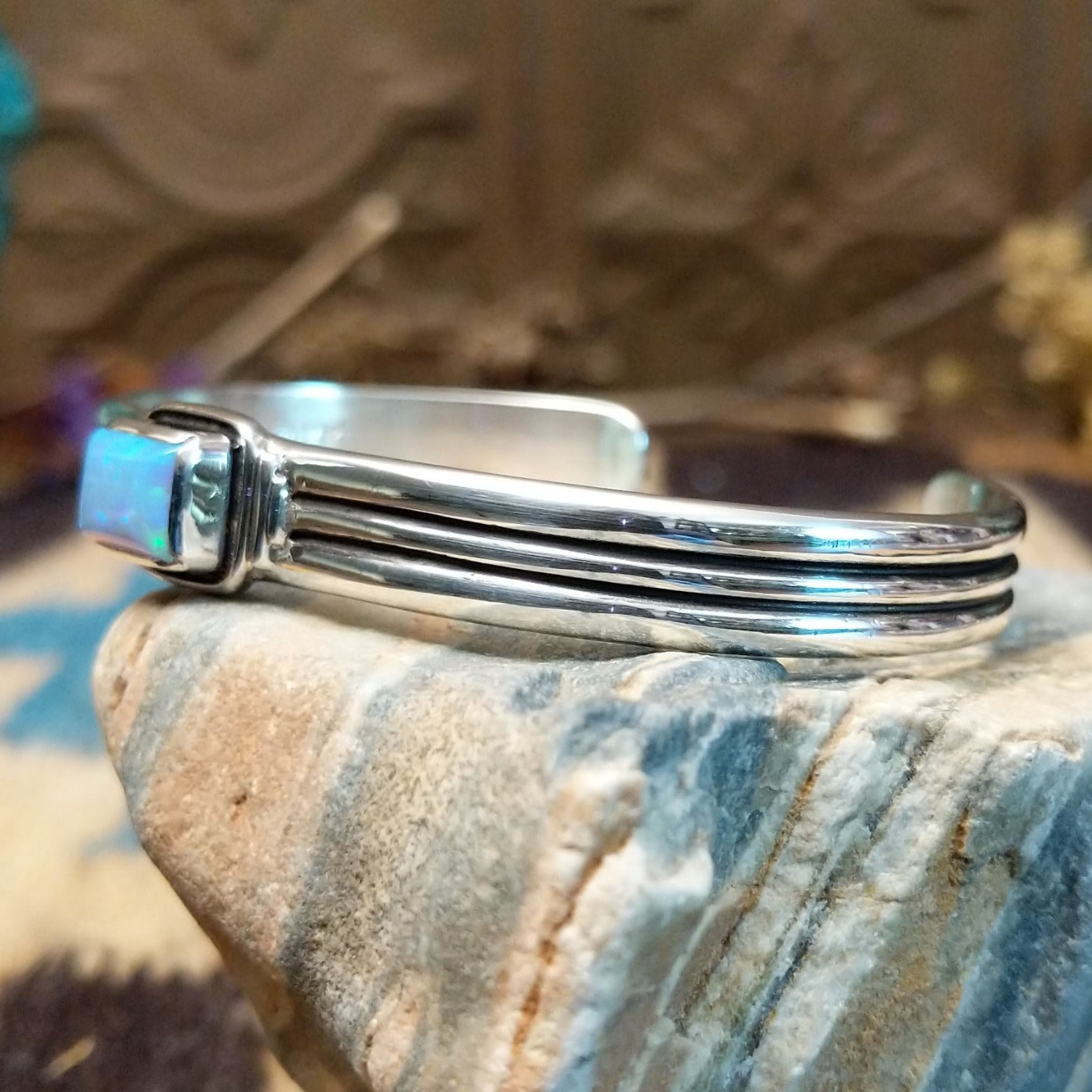 Sterling silver cuff with blue manmade opal set in a square bezel and layered band.