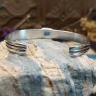 Sterling silver cuff with blue manmade opal set in a square bezel and layered band.