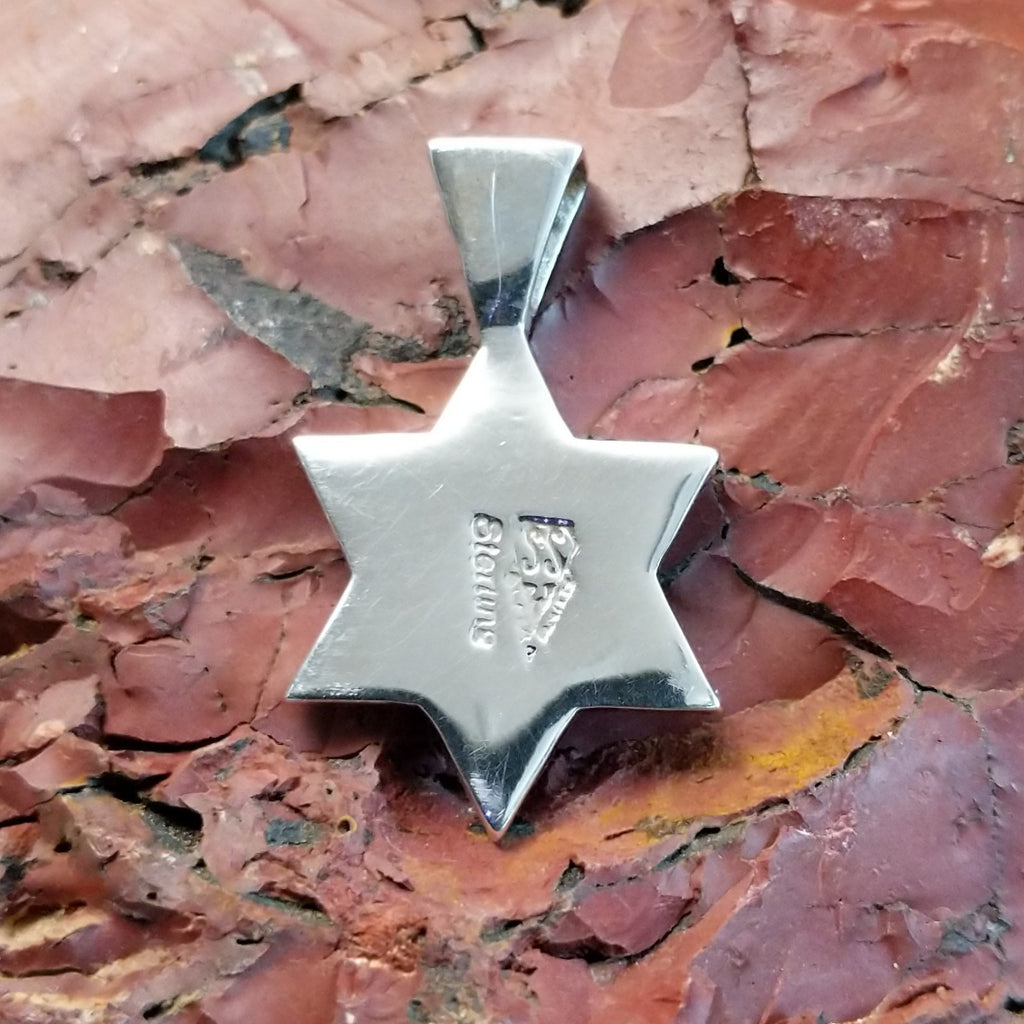 The back of the pendant features the authentication stamp.