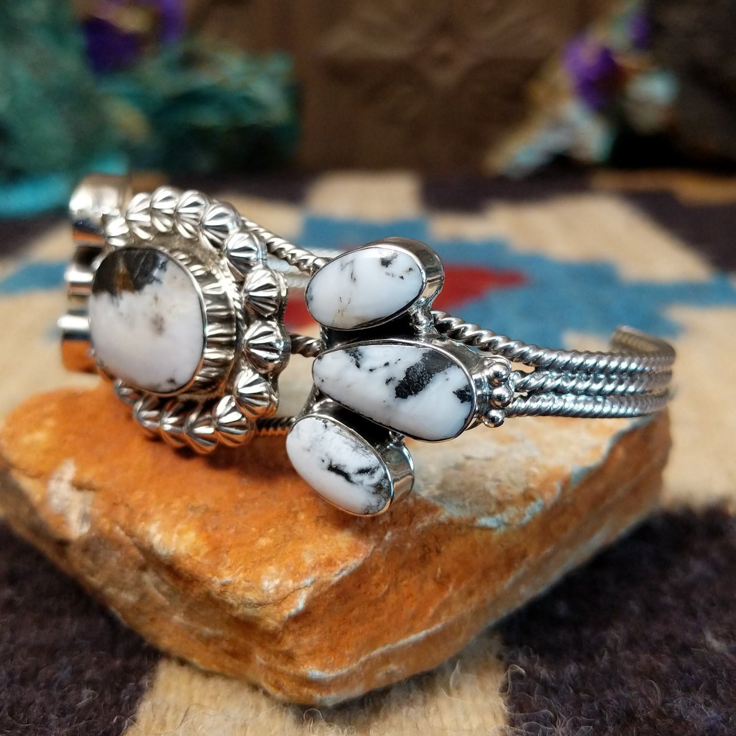 Navajo Starry White Buffalo cuff, featuring a white buffalo stone with bold black matrix patterns set in handcrafted Southwestern-inspired metalwork.  Side view.