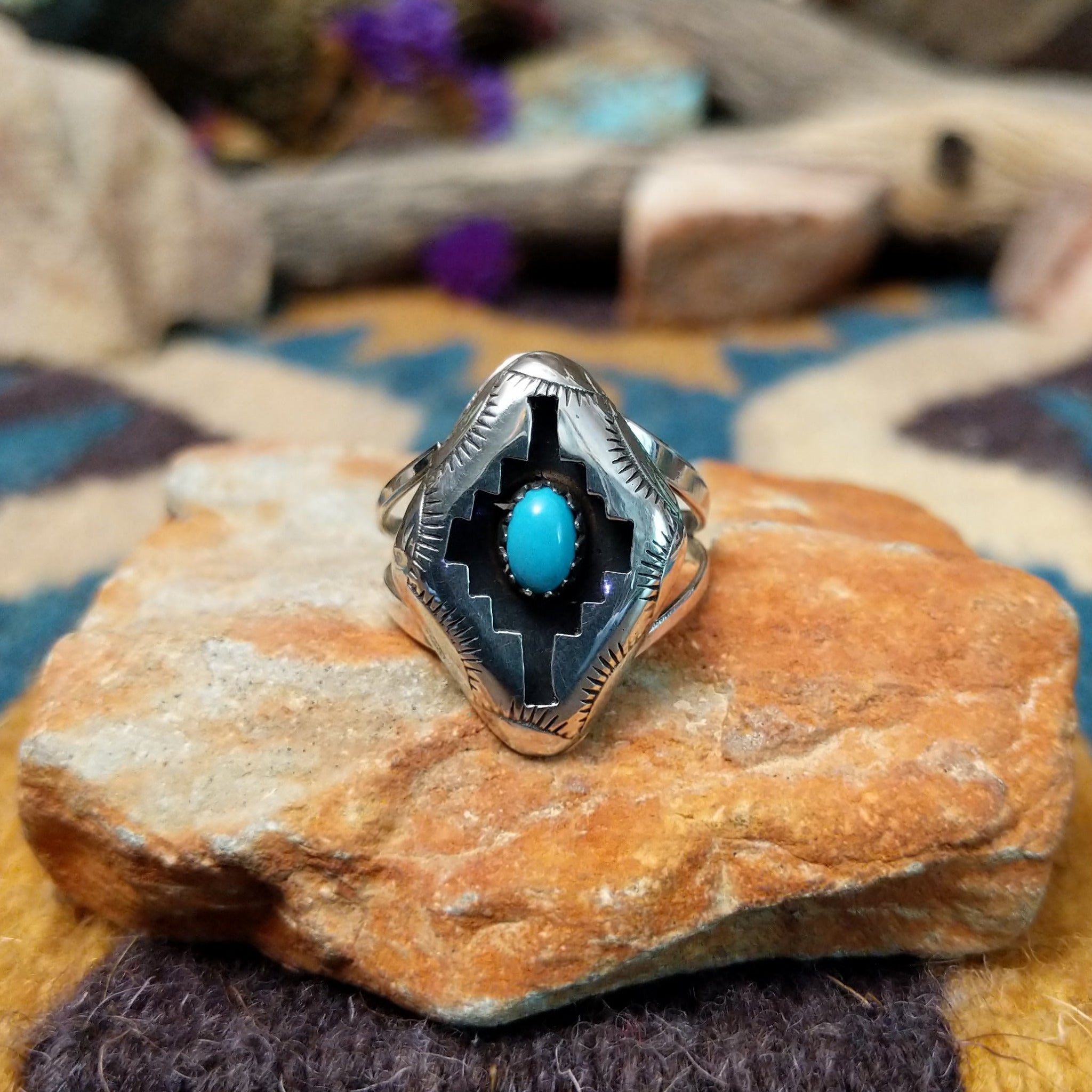 Handcrafted Navajo sterling silver shadowbox ring by P. featuring an oval turquoise cabochon set within a stepped geometric shadowbox design with hand-stamped details and an oxidized finish.