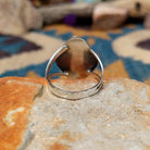 Handcrafted Navajo sterling silver shadowbox ring by P. featuring an oval turquoise cabochon set within a stepped geometric shadowbox design with hand-stamped details and an oxidized finish; underside view.