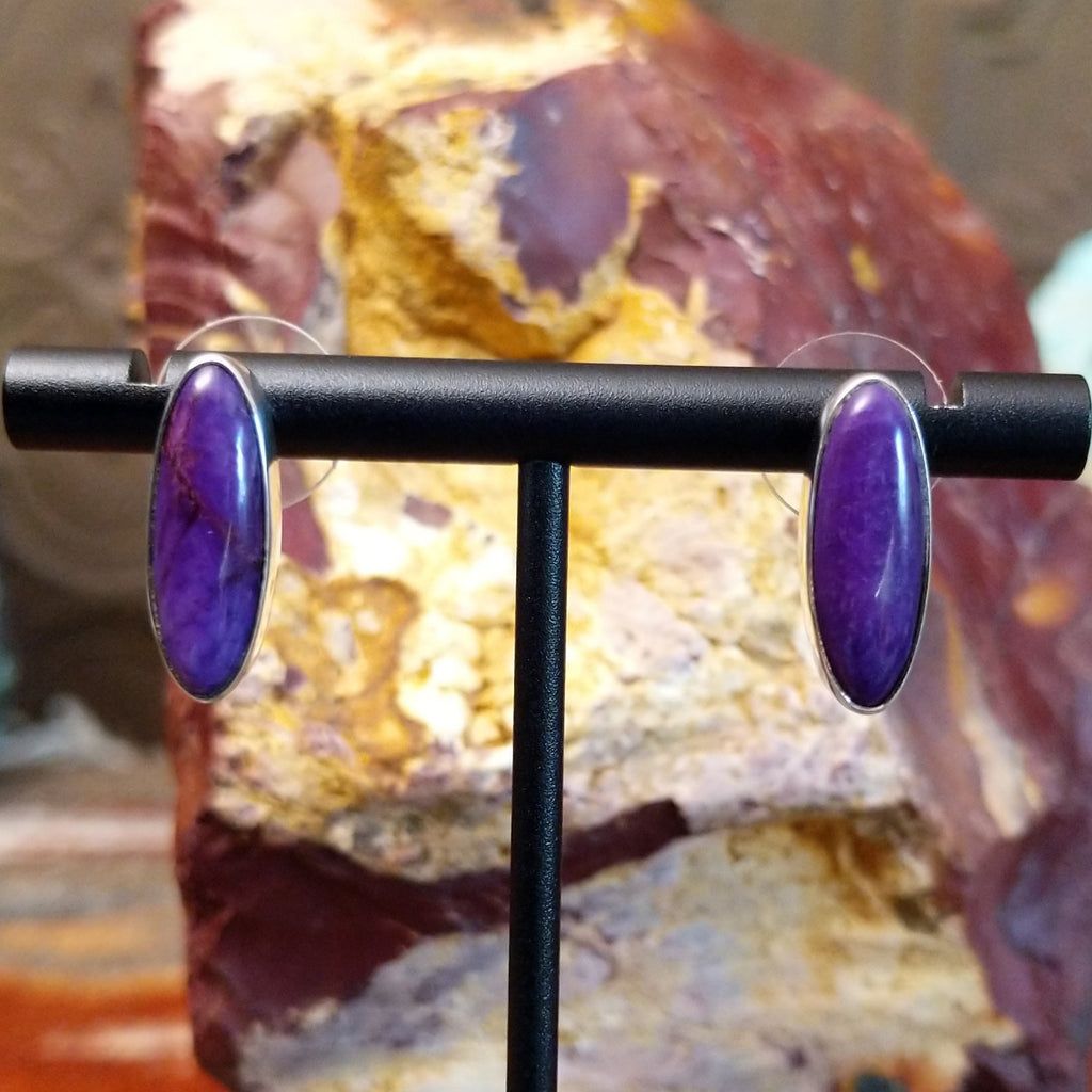 Oval sugilite set within the sterling silver bezels of the earrings.