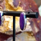 Oval sugilite set within the sterling silver bezels of the earrings.