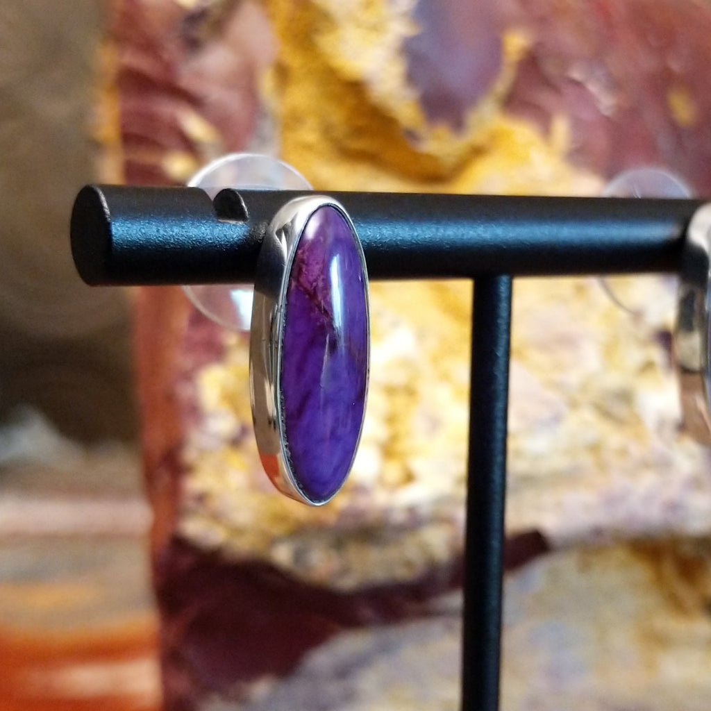 Oval sugilite set within the sterling silver bezels of the earrings.