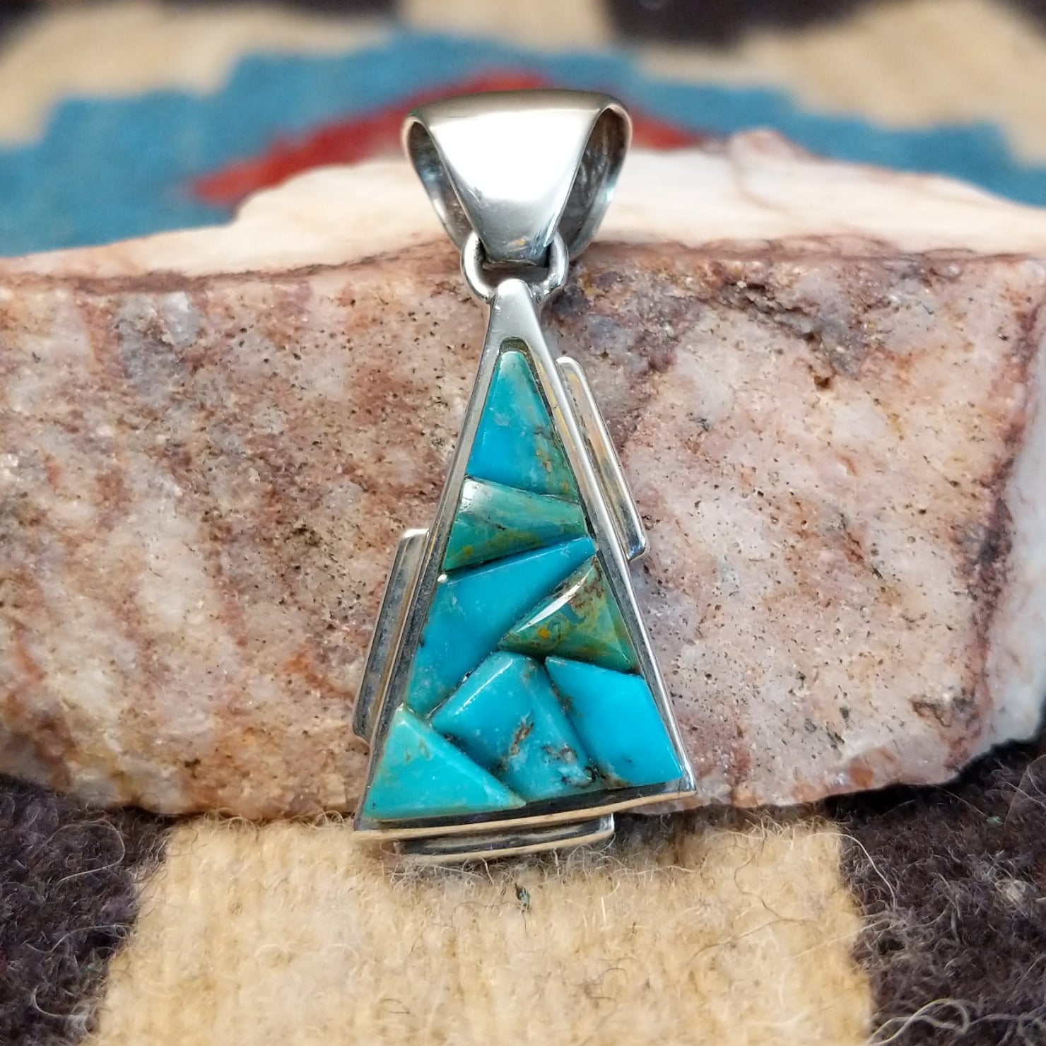 Sterling silver pendant with turquoise inlaid in the triangular bezel.