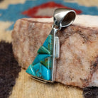 Sterling silver pendant with turquoise inlaid in the triangular bezel.
