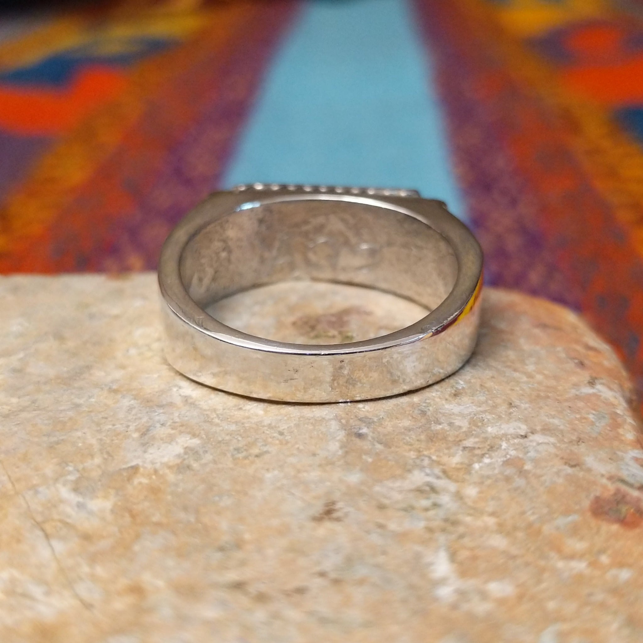 Navajo Turquoise Bar Ring by A.Q.J. featuring a rectangular bright blue turquoise stone with subtle matrix, framed by twisted-rope silverwork and decorative stamped details; underside view.