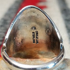 Navajo silver ring featuring a dark bear claw, oval turquoise stone, and detailed feather, scroll, and bead-style silverwork in an elongated statement design; artisan and Sterling Silver stamp.