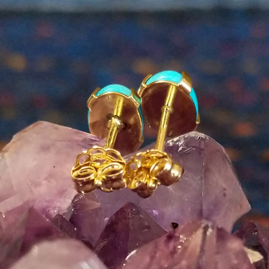 The backings of the stud earrings in gold.