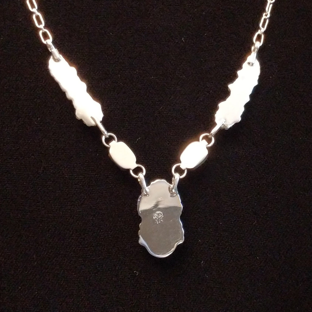 The back features the polished sterling silver settings.