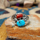 Sterling silver Navajo ring by S. featuring genuine turquoise and red coral cabochons, silver raindrop accents, and a split-shank Southwestern design.