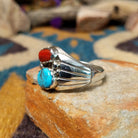 Sterling silver Navajo ring by S. featuring genuine turquoise and red coral cabochons, silver raindrop accents, and a split-shank Southwestern design; side view.