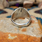 Sterling silver Navajo ring by S. featuring genuine turquoise and red coral cabochons, silver raindrop accents, and a split-shank Southwestern design; underside view.