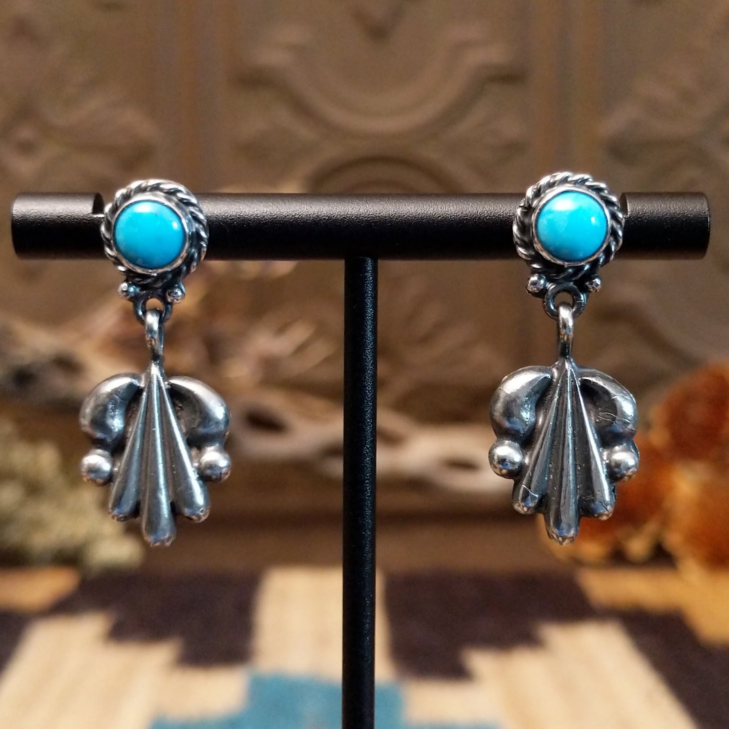 Sterling silver earrings with turquoise set in the posts, framed by twisted rope and unique silverwork designs.