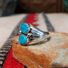 Navajo Turquoise Duo Ring by S. featuring two bright blue turquoise stones with dark matrix, silver bead accents, and a wide detailed silver band; side view.
