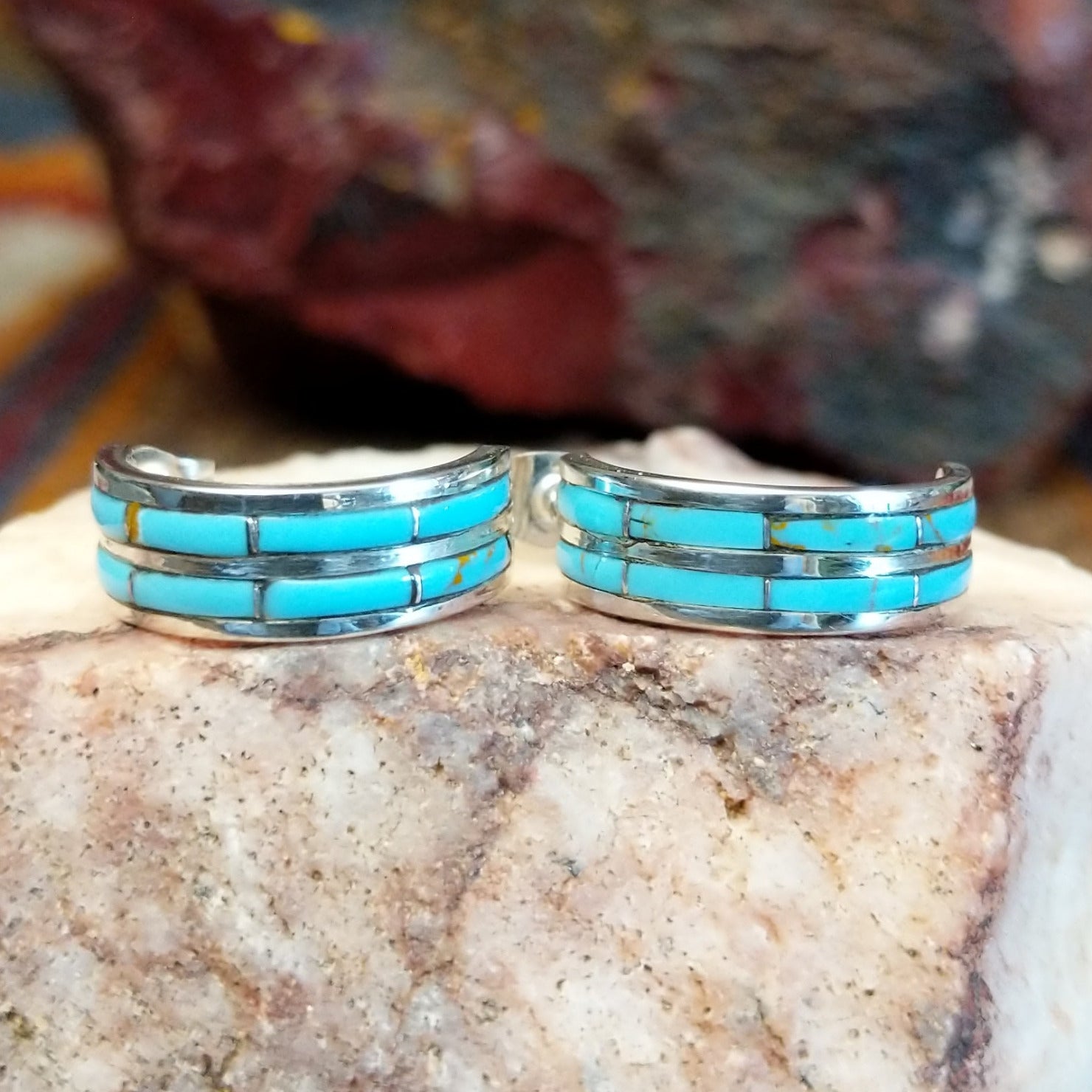 Sterling silver half hoop earrings with inlaid turquoise.