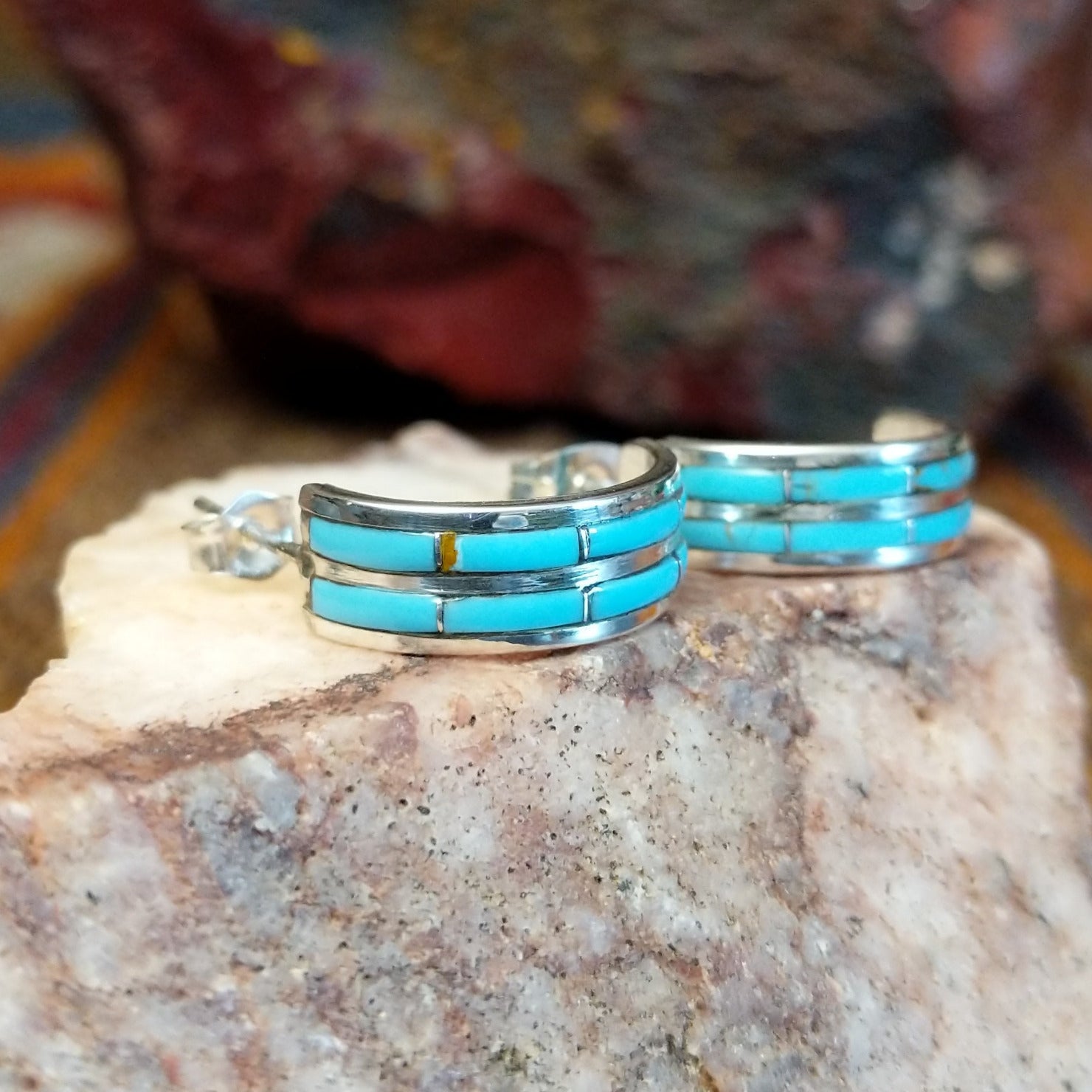 Sterling silver half hoop earrings with inlaid turquoise.