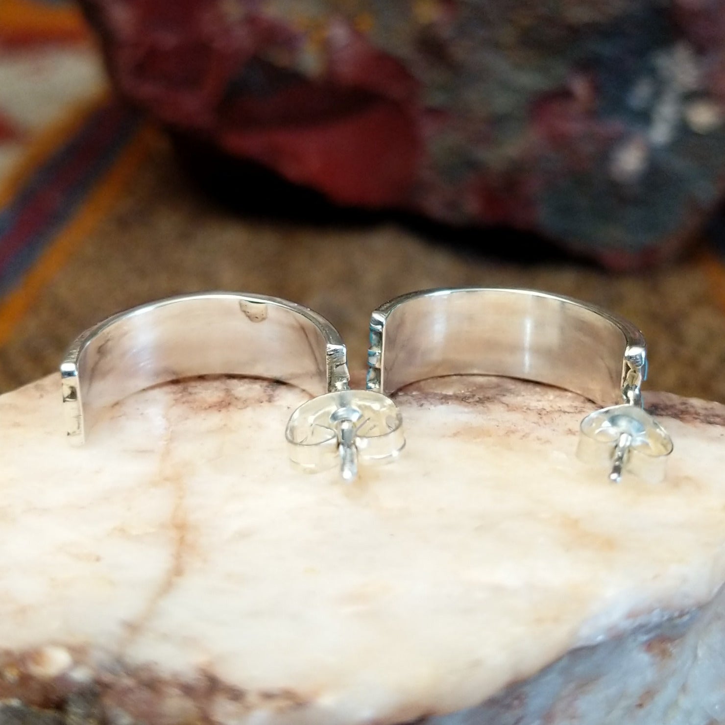 Sterling silver half hoop earrings with inlaid turquoise.