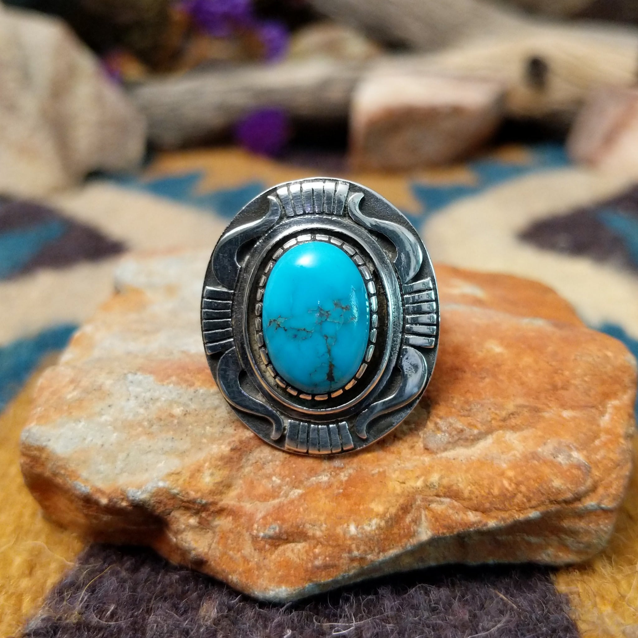 Sterling silver Navajo turquoise ring by J.M.N. with an oval sky-blue stone and hand-stamped horn design.