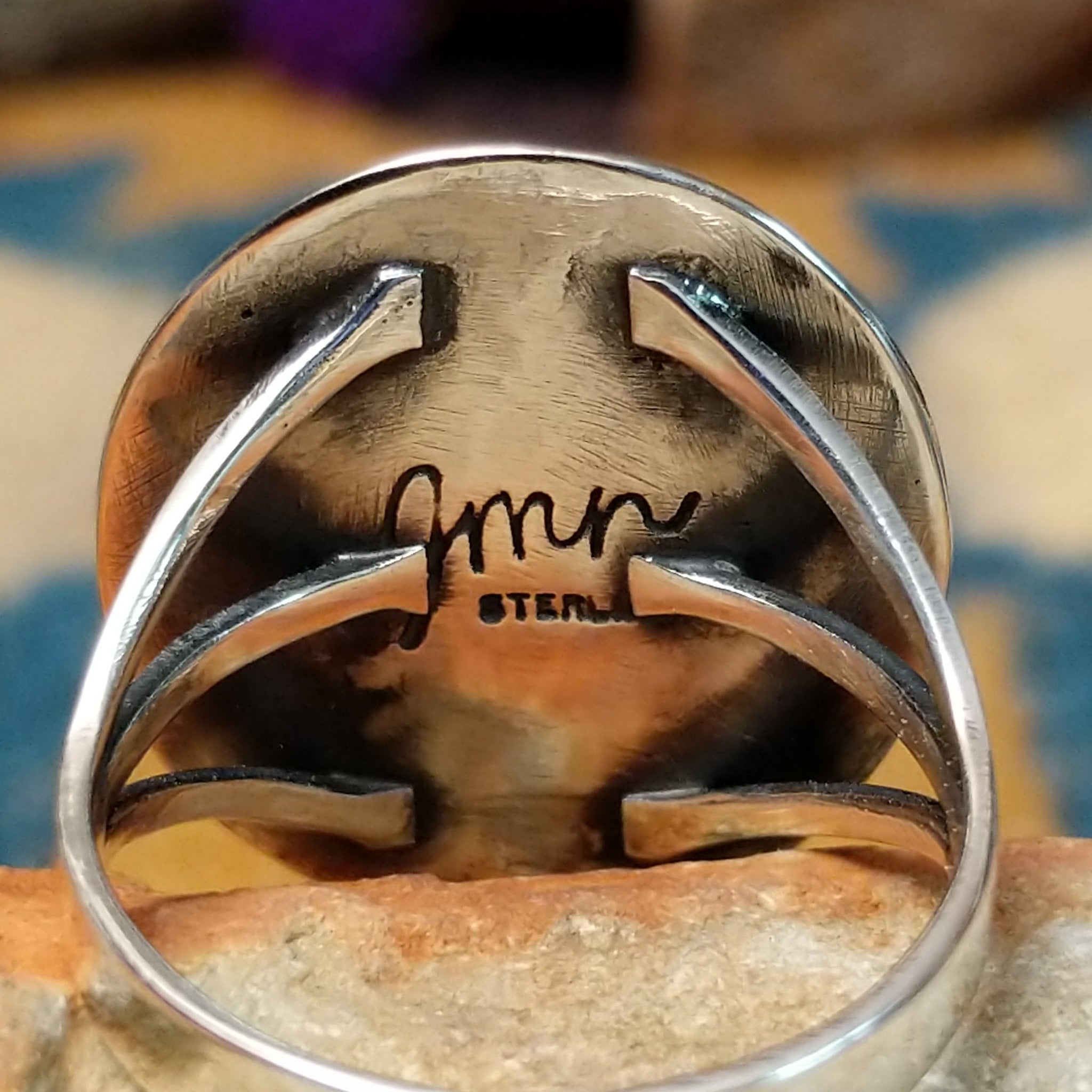 Sterling silver Navajo turquoise ring by J.M.N. with an oval sky-blue stone and hand-stamped horn design; artisan and Sterling Silver stamp.