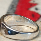 Navajo turquoise inlay ring featuring bright blue turquoise with dark matrix, segmented by polished silver channels across a wide silver band; artisan and Sterling Silver stamp.