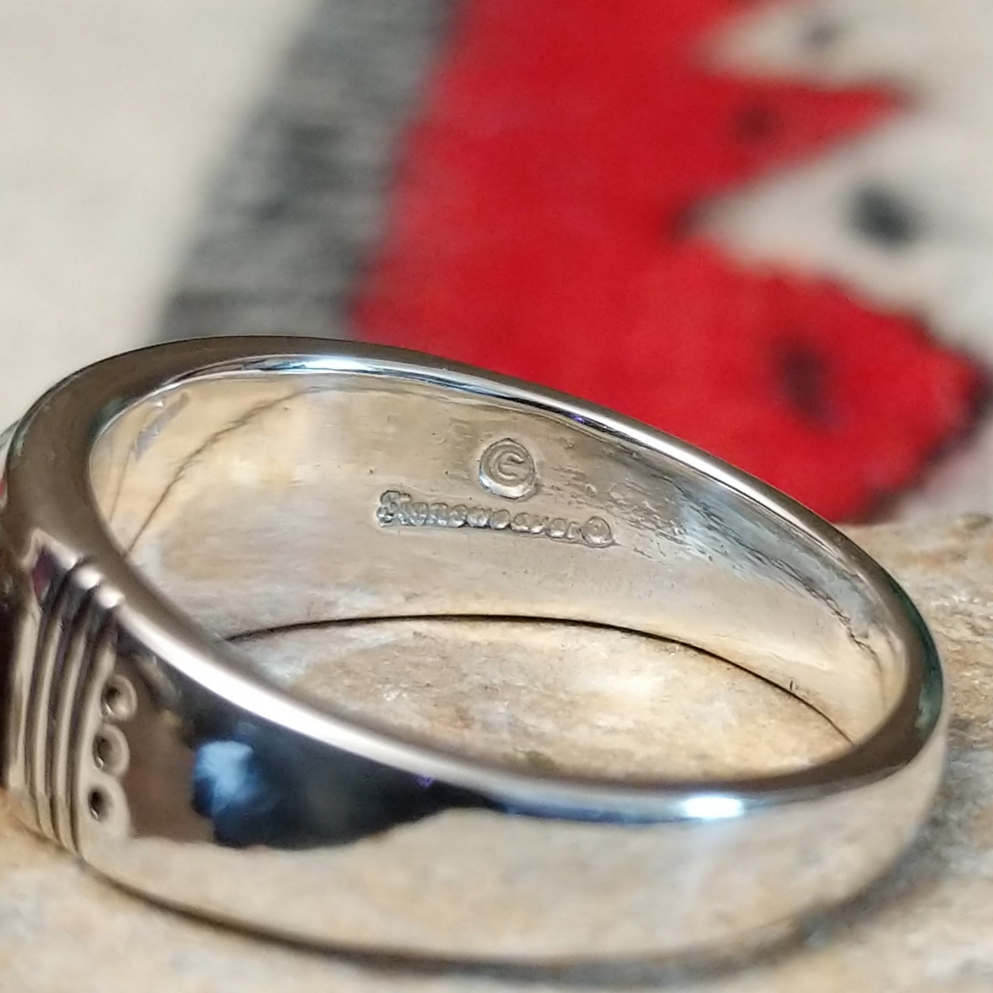 Navajo turquoise inlay ring featuring bright blue turquoise with dark matrix, segmented by polished silver channels across a wide silver band; artisan and Sterling Silver stamp.
