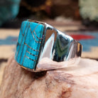 Sterling silver ring featuring a rectangular turquoise inlay and geometric channel work.