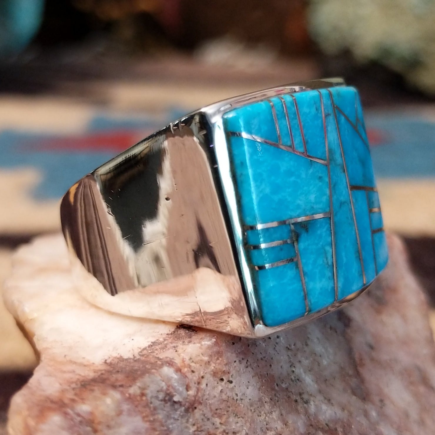 Sterling silver ring featuring a rectangular turquoise inlay and geometric channel work.