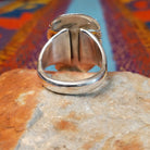 Navajo Turquoise Mountain Turquoise Ring by S.N. featuring a large rounded rectangular turquoise stone with golden-brown matrix, framed by detailed twisted-rope and decorative silverwork; underside view.
