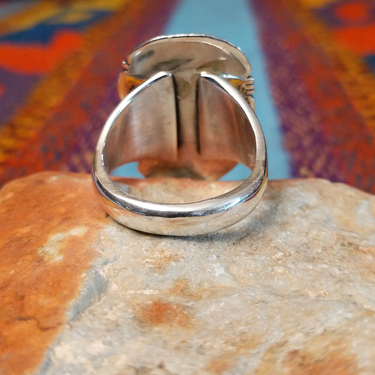 Navajo Turquoise Mountain Turquoise Ring by S.N. featuring a large rounded rectangular turquoise stone with golden-brown matrix, framed by detailed twisted-rope and decorative silverwork; underside view.