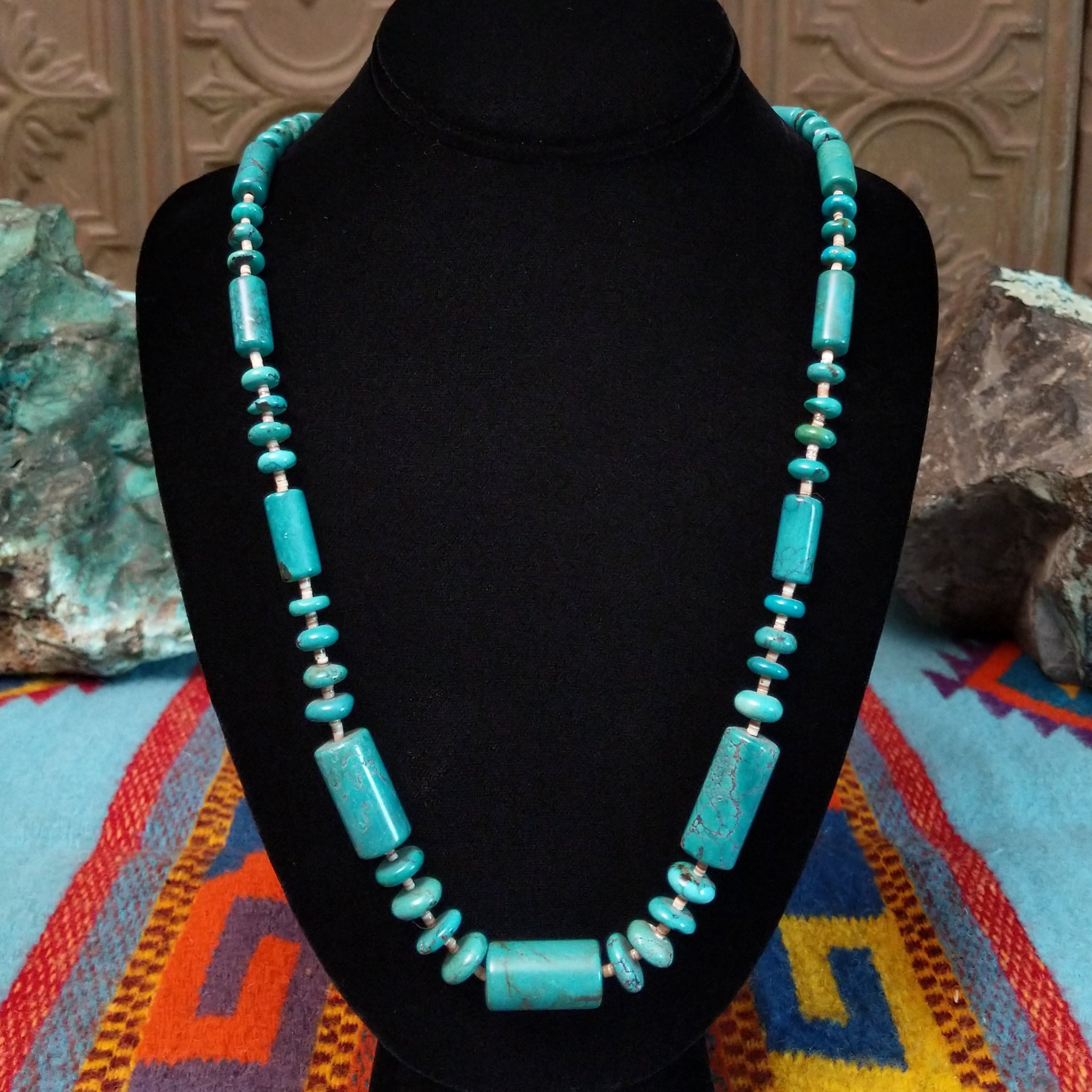 Long necklace featuring turquoise beads, large rectangular turquoise beads, and light pen shell spacers