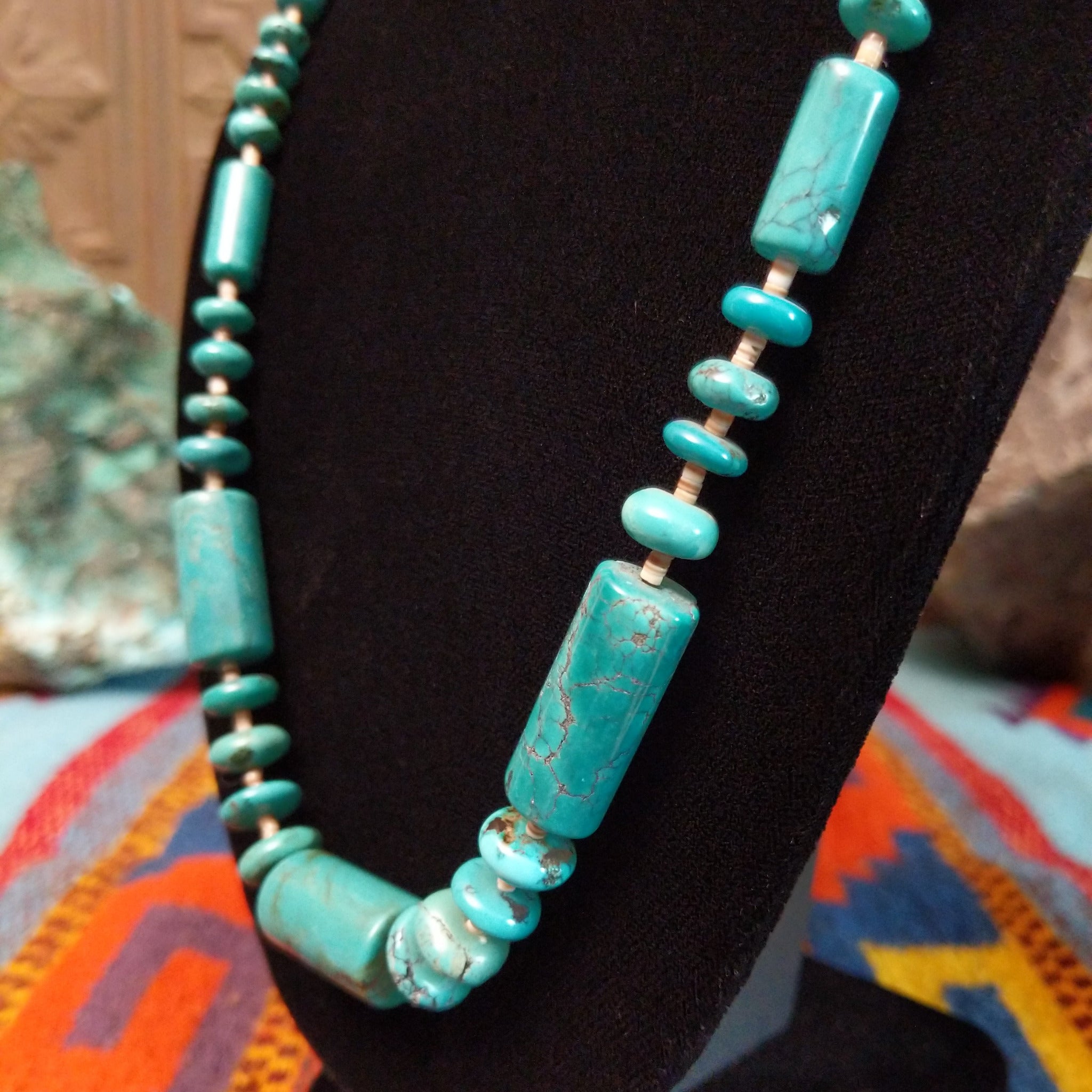 Long necklace featuring turquoise beads, large rectangular turquoise beads, and light pen shell spacers