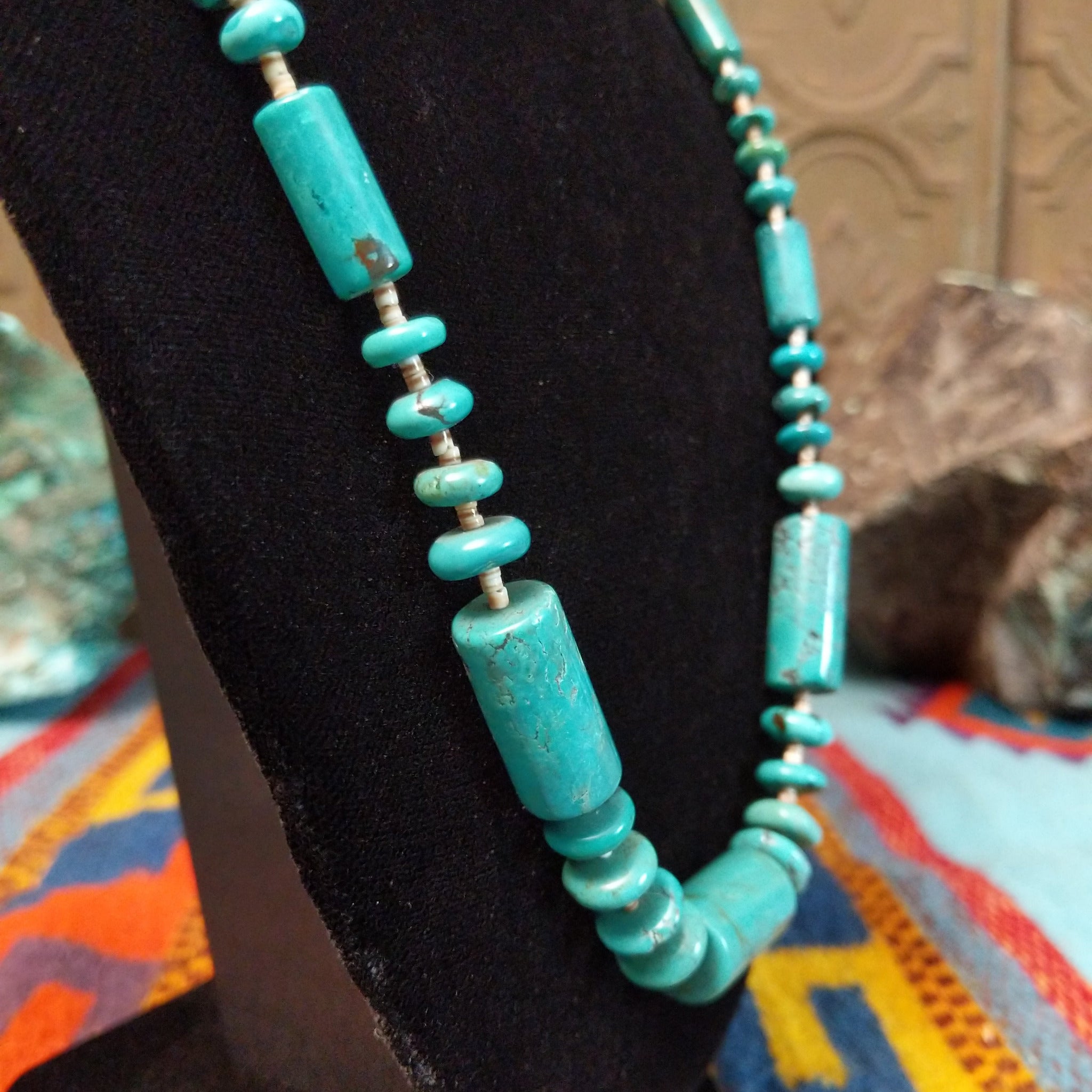 Long necklace featuring turquoise beads, large rectangular turquoise beads, and light pen shell spacers