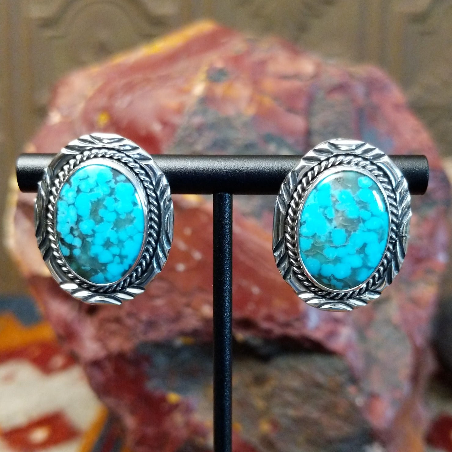 Sterling silver earrings with turquoise set in the bezels, framed by twisted rope and intricate stamping.