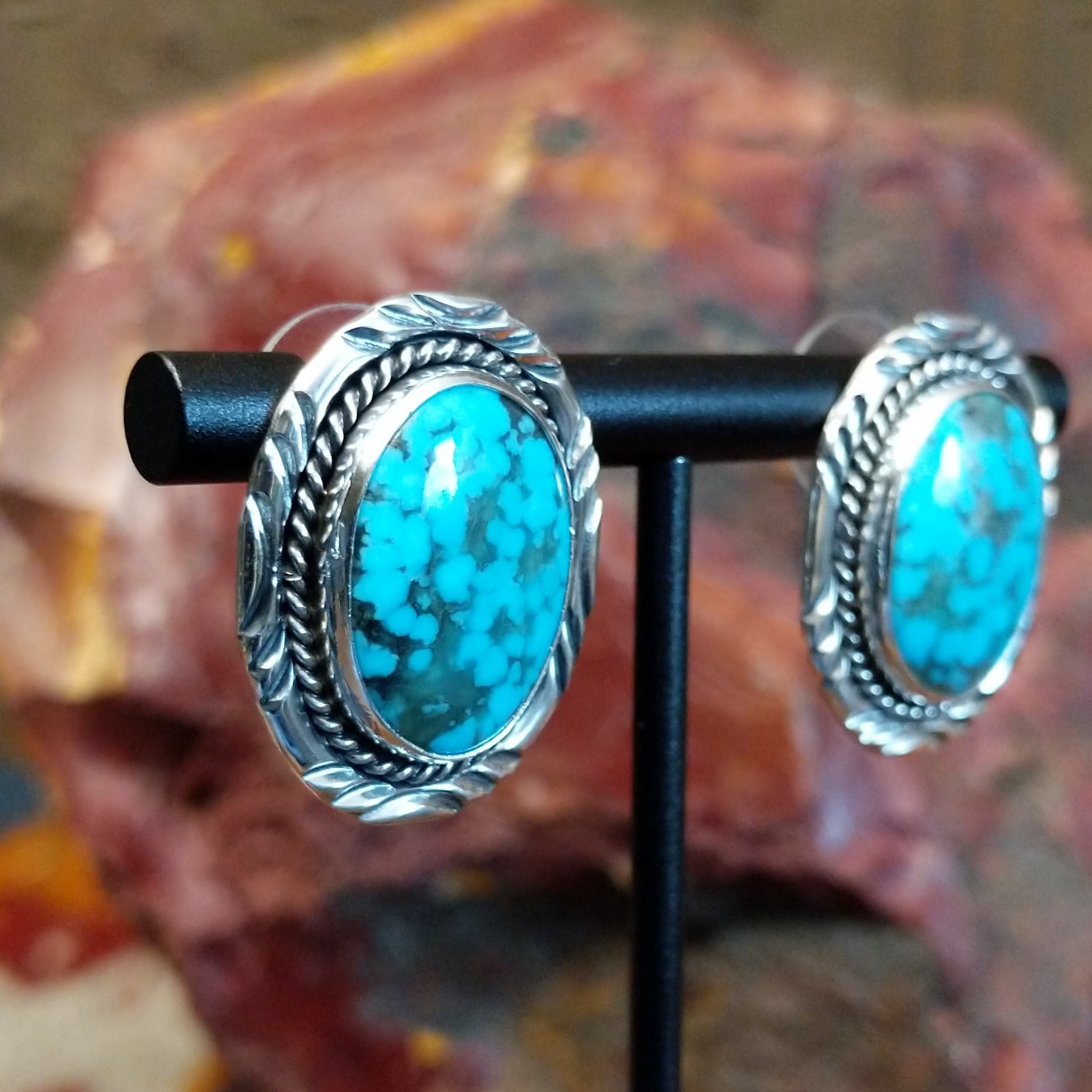 Sterling silver earrings with turquoise set in the bezels, framed by twisted rope and intricate stamping.