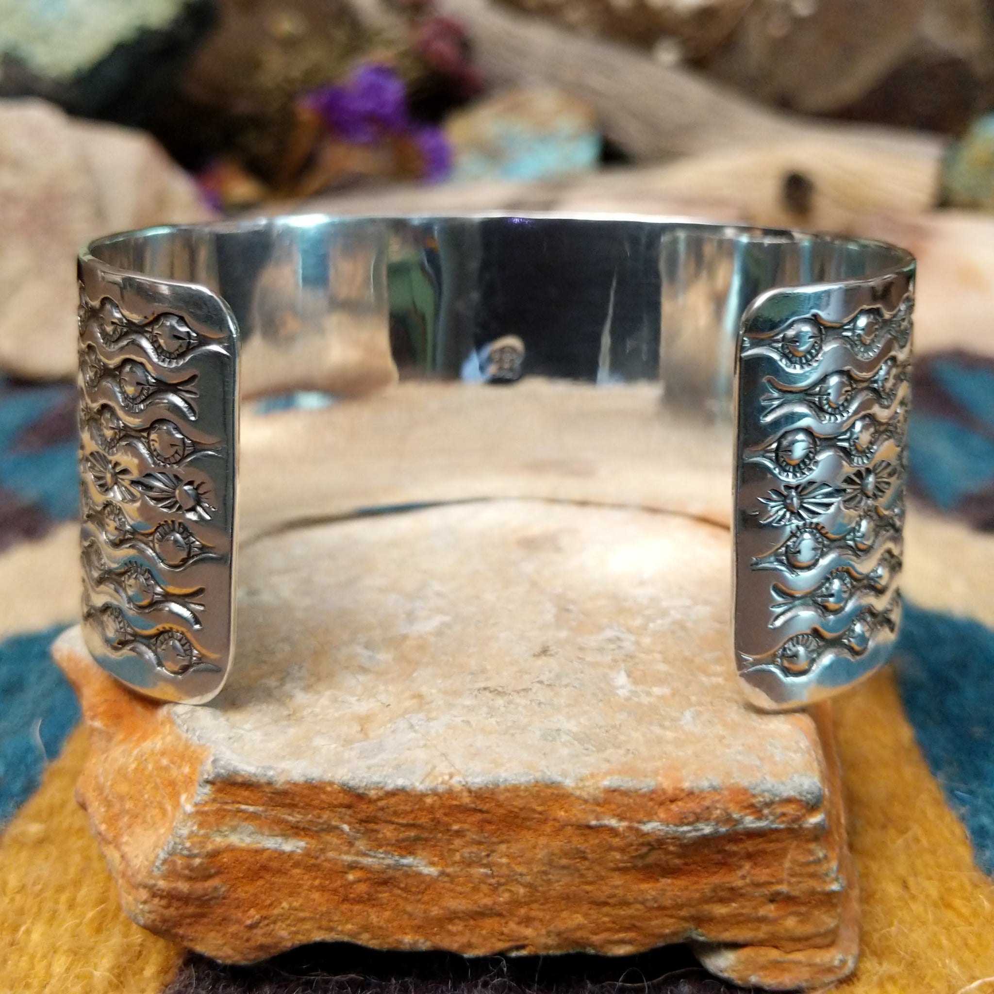 Handcrafted Navajo sterling silver cuff featuring five diamond-shaped turquoise stones in twisted rope bezels with intricate hand-stamped Southwestern designs and silver bead accents; underside view.