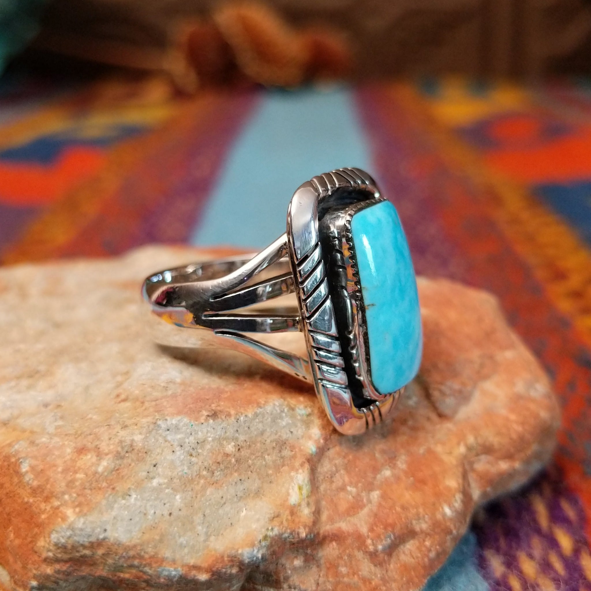 Navajo Turquoise Rectangle Ring featuring a large rectangular turquoise stone set in Sterling Silver with bold geometric stamped detailing and a split-shank band; side view.