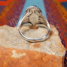 Navajo Turquoise Ring featuring a large elongated oval turquoise stone with natural brown and dark matrix, framed by twisted rope detailing and set in Sterling Silver with a split-shank band; underside view.